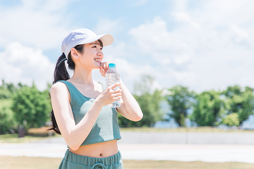 運動している女性が水分補給をしている様子